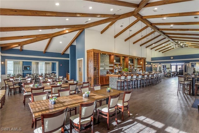 dining room featuring beam ceiling, high vaulted ceiling, and dark hardwood / wood-style floors