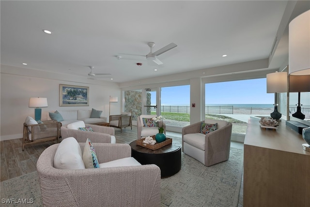 living room featuring a water view, ceiling fan, and hardwood / wood-style flooring