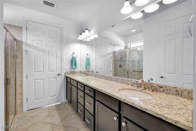 bathroom featuring tile patterned flooring, vanity, and walk in shower