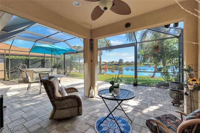 view of patio featuring a water view, ceiling fan, and a lanai