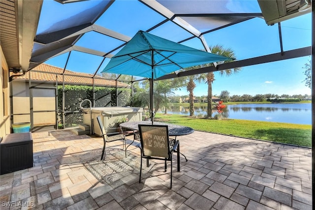 view of patio featuring a water view, a lanai, and a hot tub