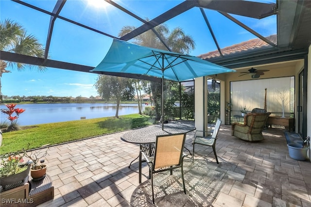 view of patio / terrace with ceiling fan, a water view, and glass enclosure