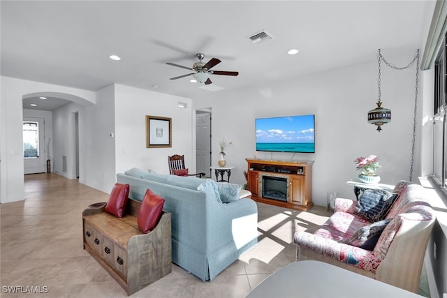 living room with arched walkways, recessed lighting, a fireplace, a ceiling fan, and visible vents