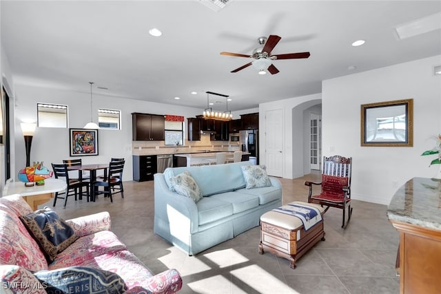 living area featuring arched walkways, light tile patterned floors, recessed lighting, visible vents, and ceiling fan