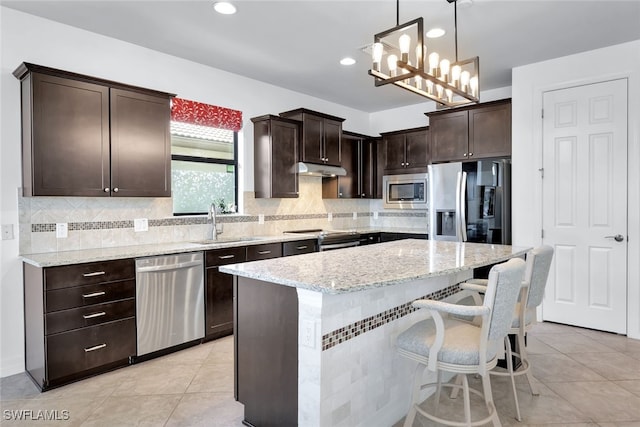 kitchen featuring dark brown cabinetry, light tile patterned floors, light stone countertops, stainless steel appliances, and a sink