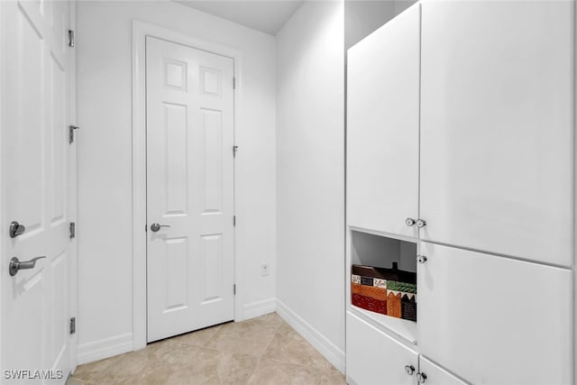 interior space featuring baseboards and light tile patterned flooring