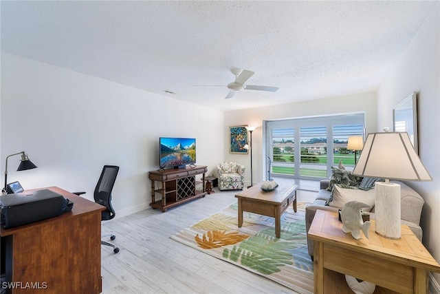 office area with ceiling fan, light hardwood / wood-style flooring, and a textured ceiling