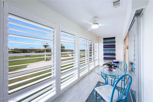 sunroom / solarium featuring ceiling fan