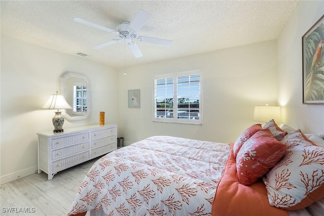 bedroom featuring a textured ceiling, ceiling fan, and light hardwood / wood-style floors