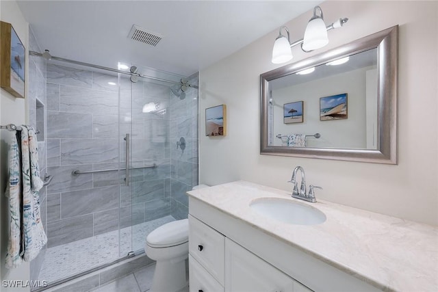 bathroom featuring walk in shower, vanity, toilet, and tile patterned flooring