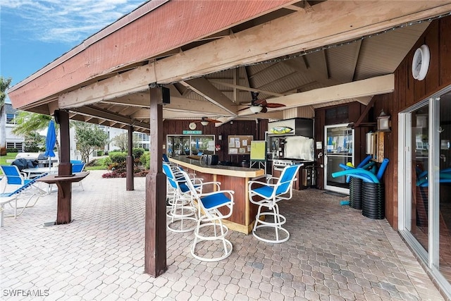 view of patio / terrace featuring ceiling fan and exterior bar