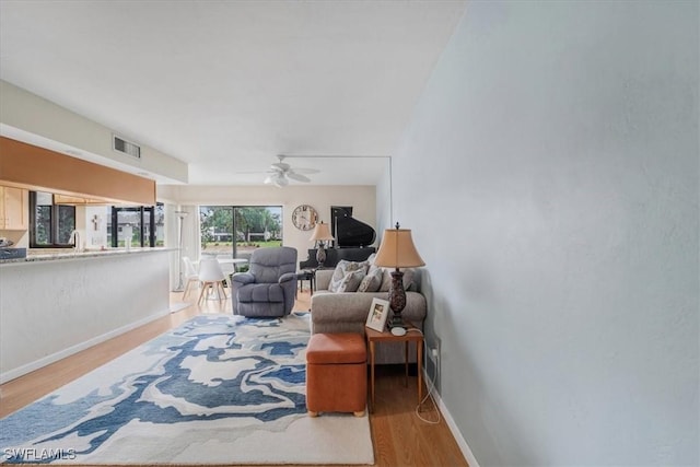 sitting room with ceiling fan and light wood-type flooring