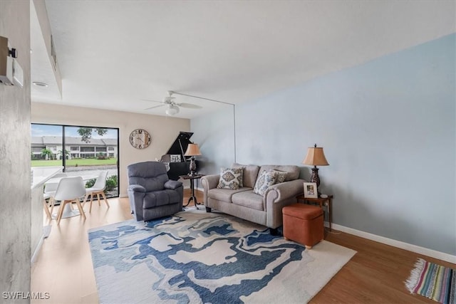 living room featuring wood-type flooring and ceiling fan