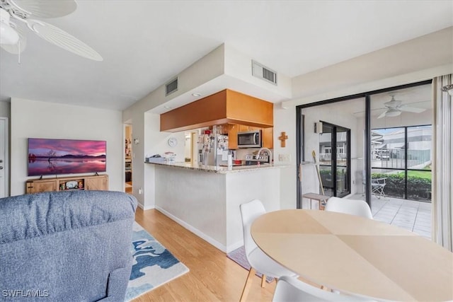 living room featuring ceiling fan and light wood-type flooring