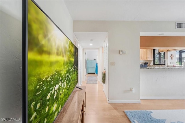 corridor featuring sink and light hardwood / wood-style floors