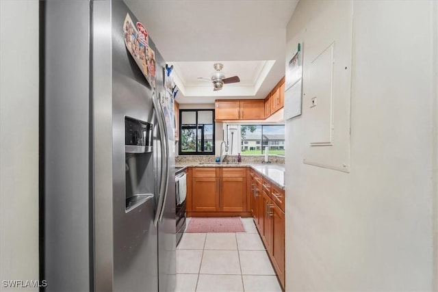 kitchen featuring light tile patterned flooring, sink, a raised ceiling, ceiling fan, and stainless steel appliances