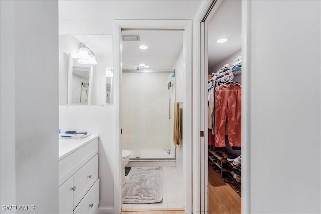 bathroom featuring vanity, toilet, tile patterned floors, and walk in shower