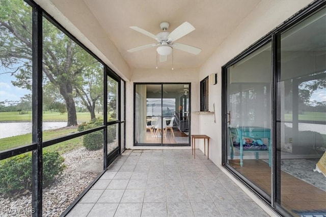 unfurnished sunroom featuring ceiling fan