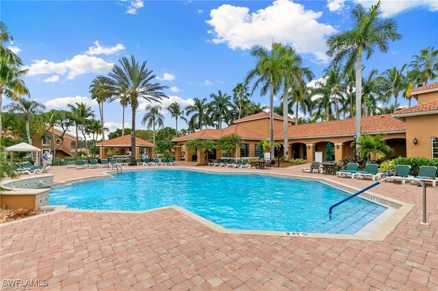 community pool with a gazebo and a patio