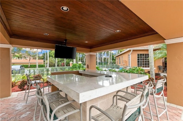 view of patio with outdoor wet bar and fence