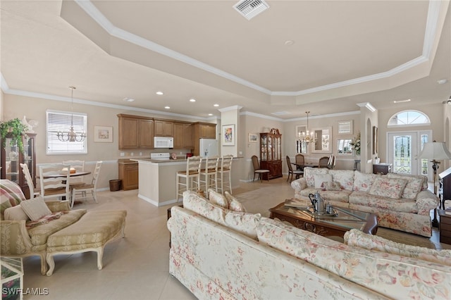 living room with an inviting chandelier, ornamental molding, a raised ceiling, and light tile patterned floors