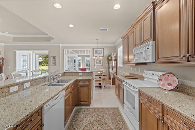 kitchen with sink, white appliances, crown molding, light stone counters, and decorative light fixtures