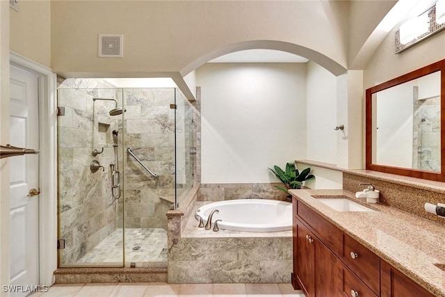 bathroom featuring vanity, tile patterned flooring, and plus walk in shower