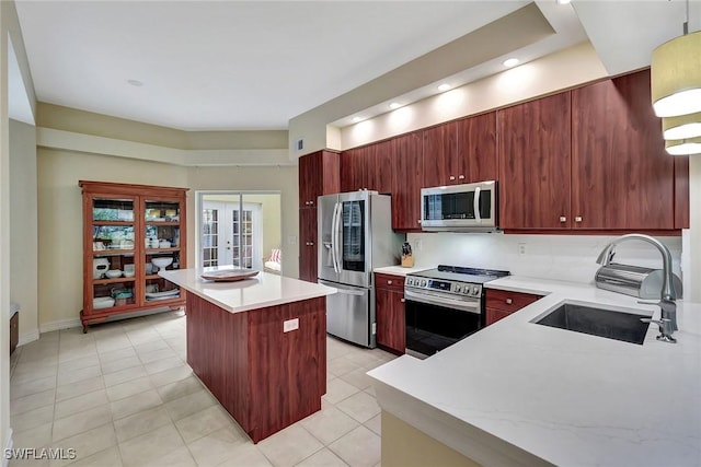 kitchen with a kitchen island, appliances with stainless steel finishes, sink, light tile patterned floors, and french doors