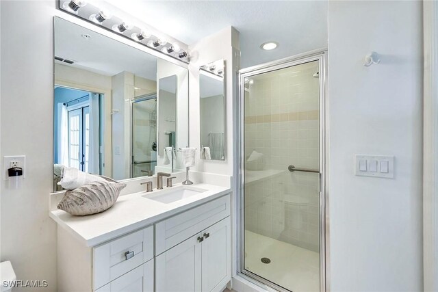 bathroom with vanity and a shower with door