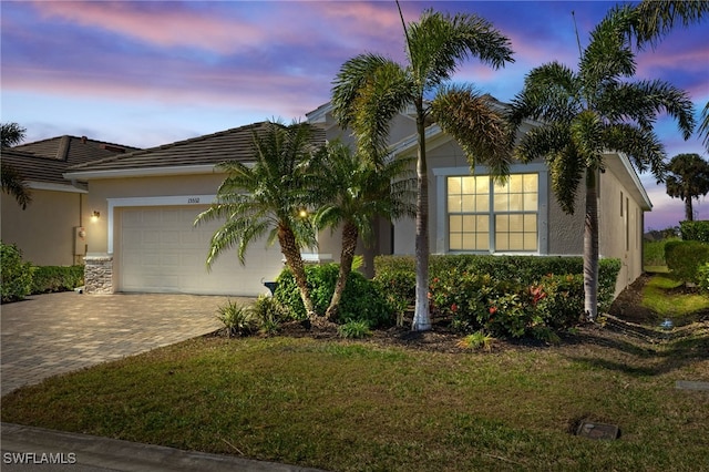 view of front of home with a garage and a lawn