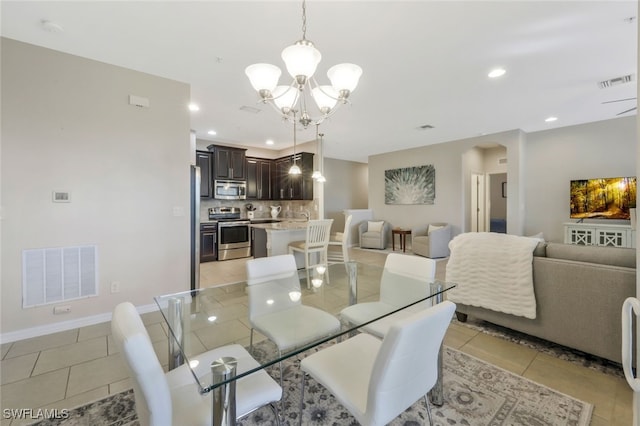 tiled dining room with a chandelier