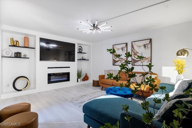 living room featuring hardwood / wood-style floors, built in shelves, and a notable chandelier