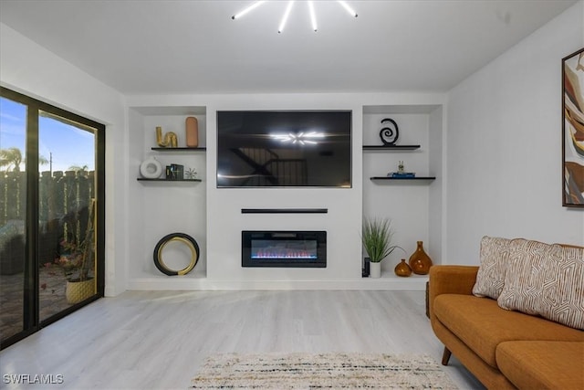 living room with light hardwood / wood-style floors and built in shelves