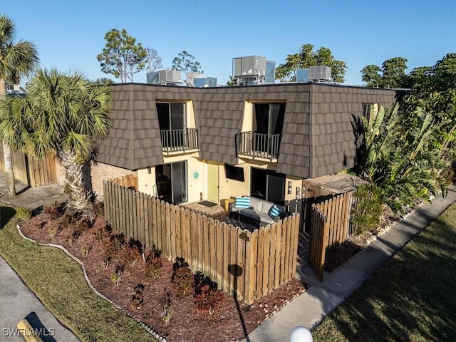 back of house with a balcony and central air condition unit