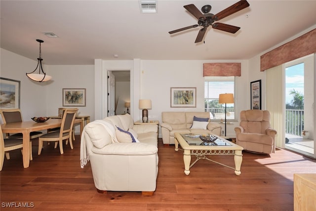 living room with dark wood-type flooring and ceiling fan