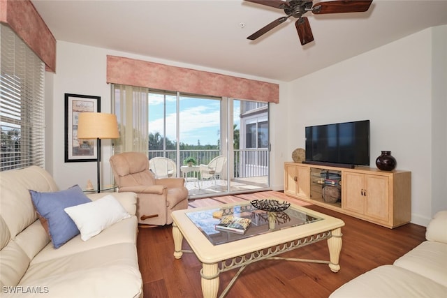 living room featuring dark wood-type flooring and ceiling fan