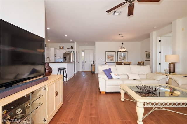 living room with light hardwood / wood-style floors and ceiling fan