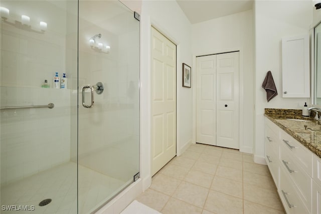 bathroom featuring vanity, tile patterned flooring, and a shower with door