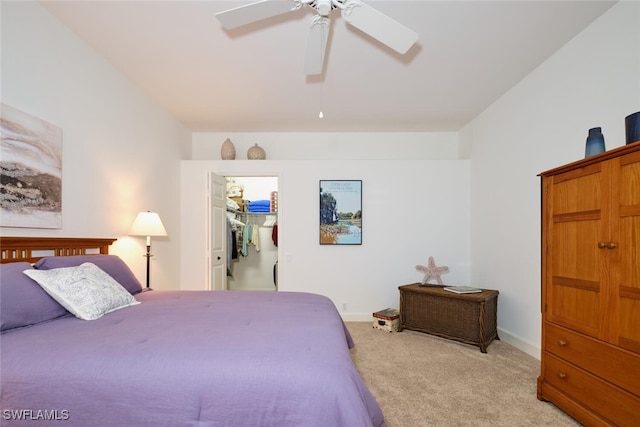 carpeted bedroom with a walk in closet, a closet, and ceiling fan