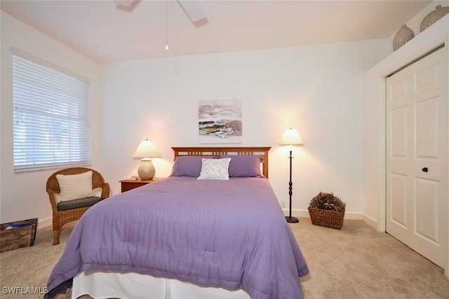 carpeted bedroom featuring a closet and ceiling fan