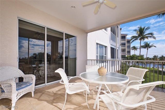 balcony with a water view and ceiling fan