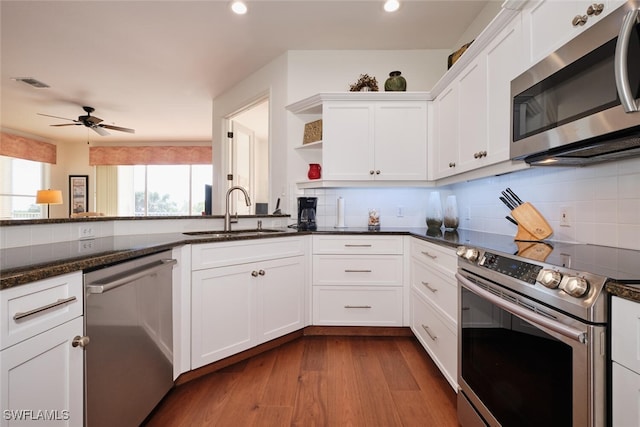 kitchen with stainless steel appliances, wood-type flooring, sink, and white cabinets