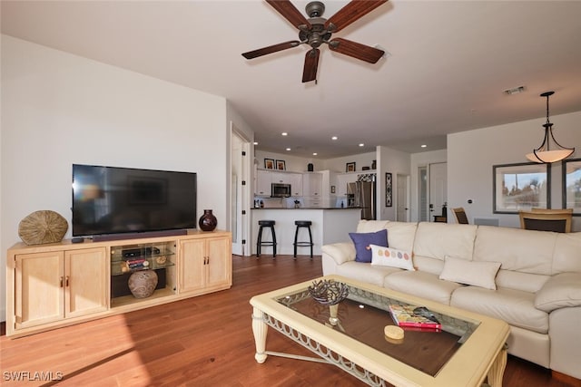 living room with hardwood / wood-style flooring and ceiling fan