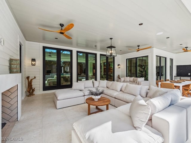 living room featuring exterior fireplace and ceiling fan