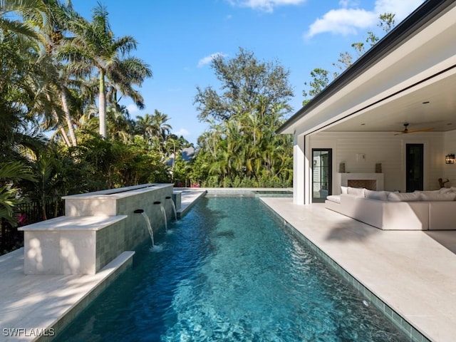 view of pool with pool water feature, a jacuzzi, outdoor lounge area, ceiling fan, and a patio