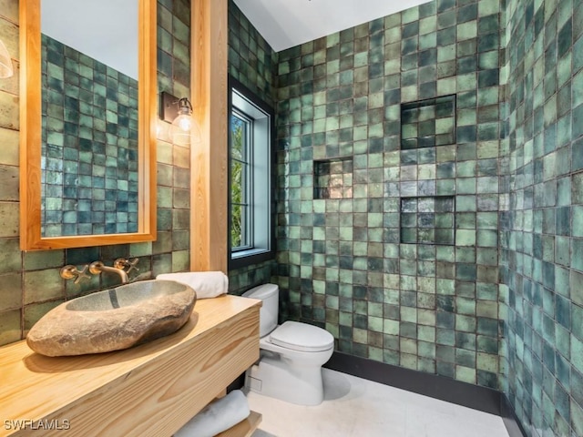 bathroom with vanity, tile walls, tile patterned floors, and toilet