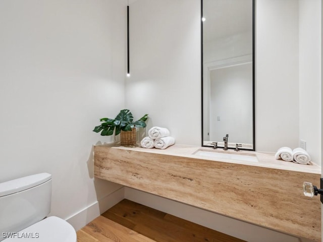 bathroom featuring vanity, wood-type flooring, and toilet