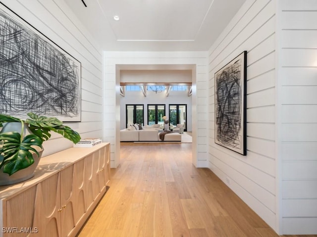 hall featuring wood walls and light wood-type flooring