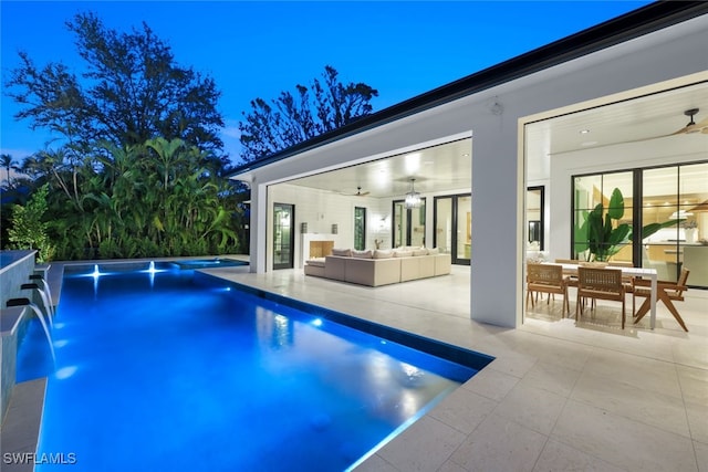 view of pool featuring pool water feature, ceiling fan, an outdoor living space, and a patio area