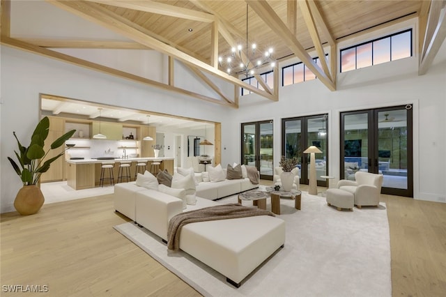 living room featuring light hardwood / wood-style flooring, wooden ceiling, french doors, and beamed ceiling